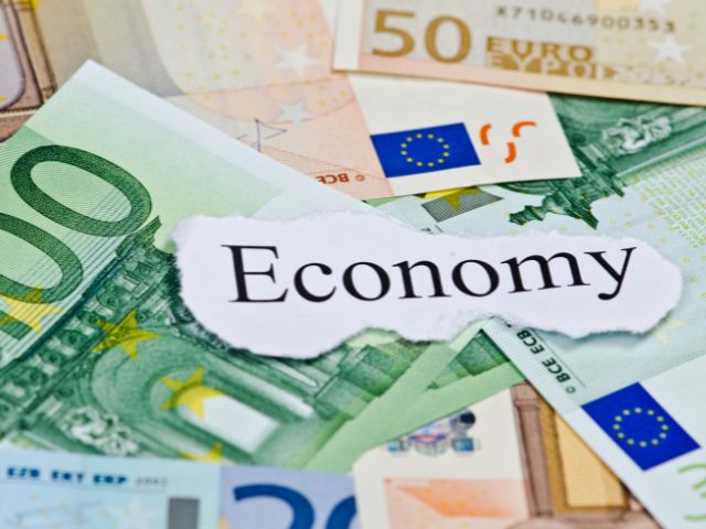景気のイメージ画像。外国の紙幣の上に、「economy」と書かれた紙。